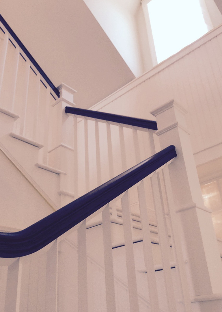 Staircase with crisp white balusters and dark stained rail